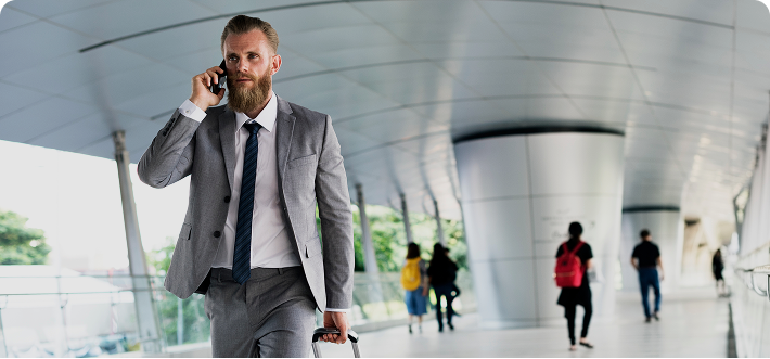 handsome-smiling-young-man-casual-clothes-with-backpack-talking-phone-carrying-laptop 1